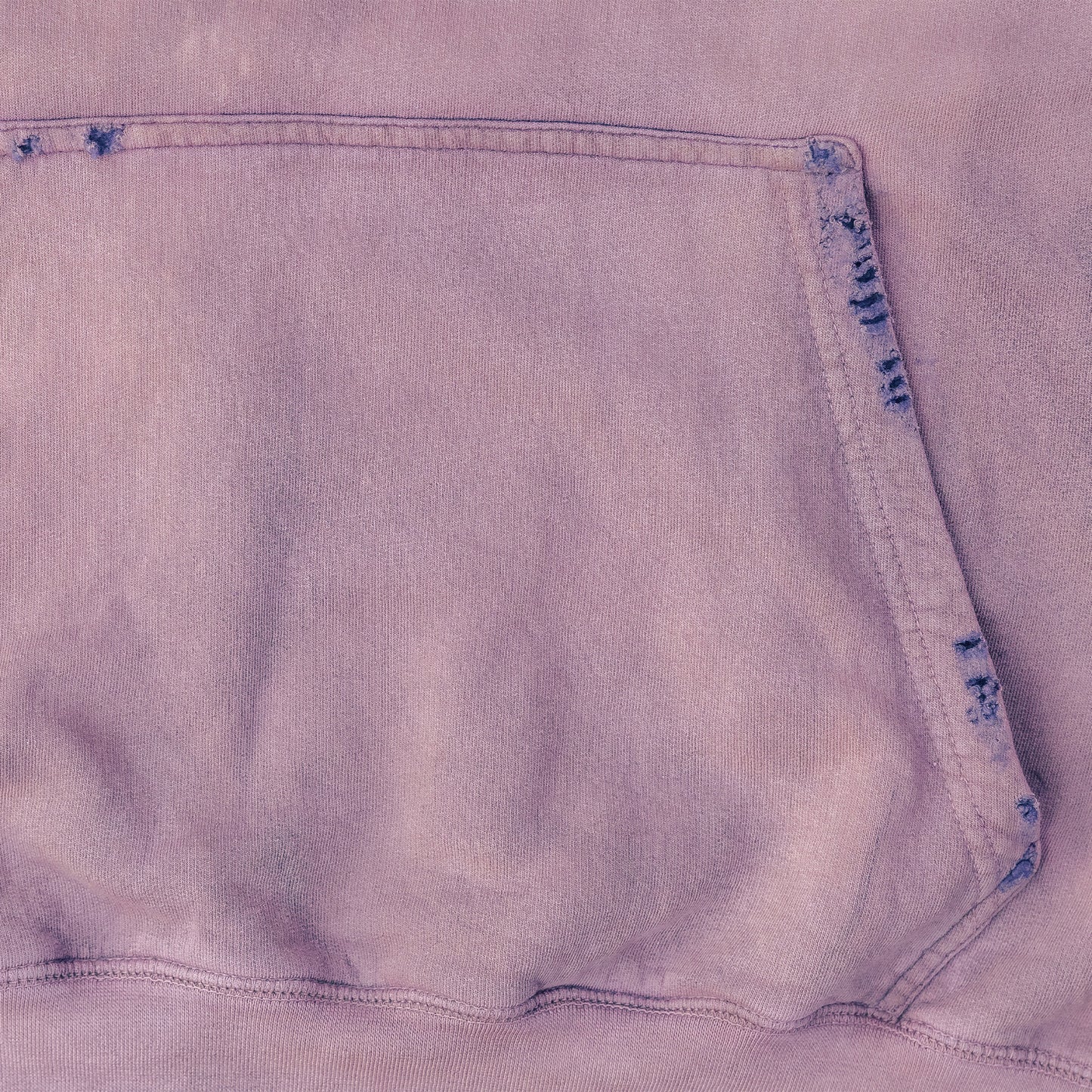 Close-up of a light purple hoodie fabric with a pocket detail