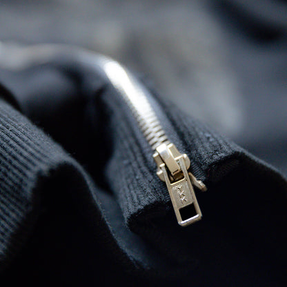 Close-up of a ykk zipper on a dark fabric background