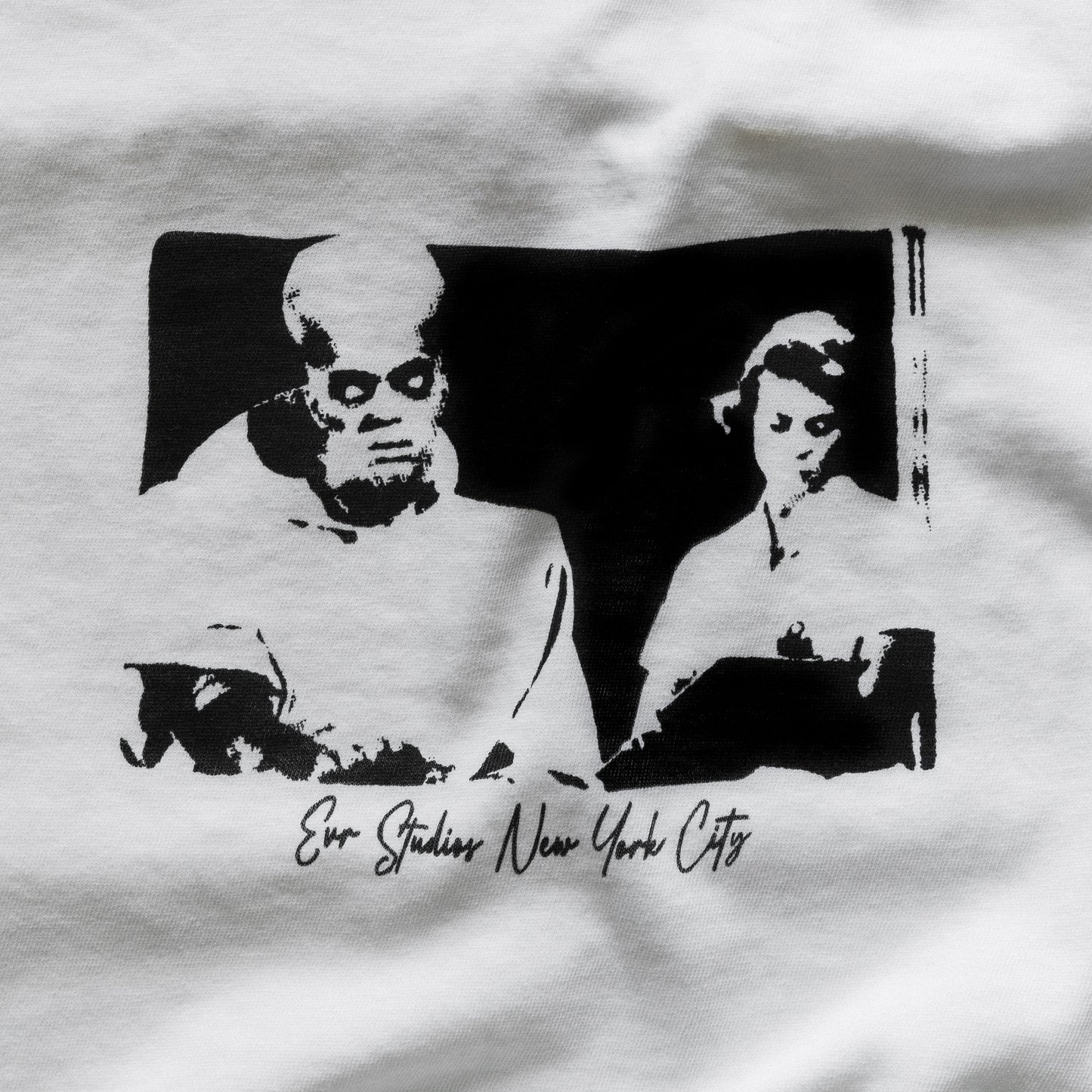 White t-shirt with black graphic design of a man and woman, featuring 'Evo Studios New York City' text.