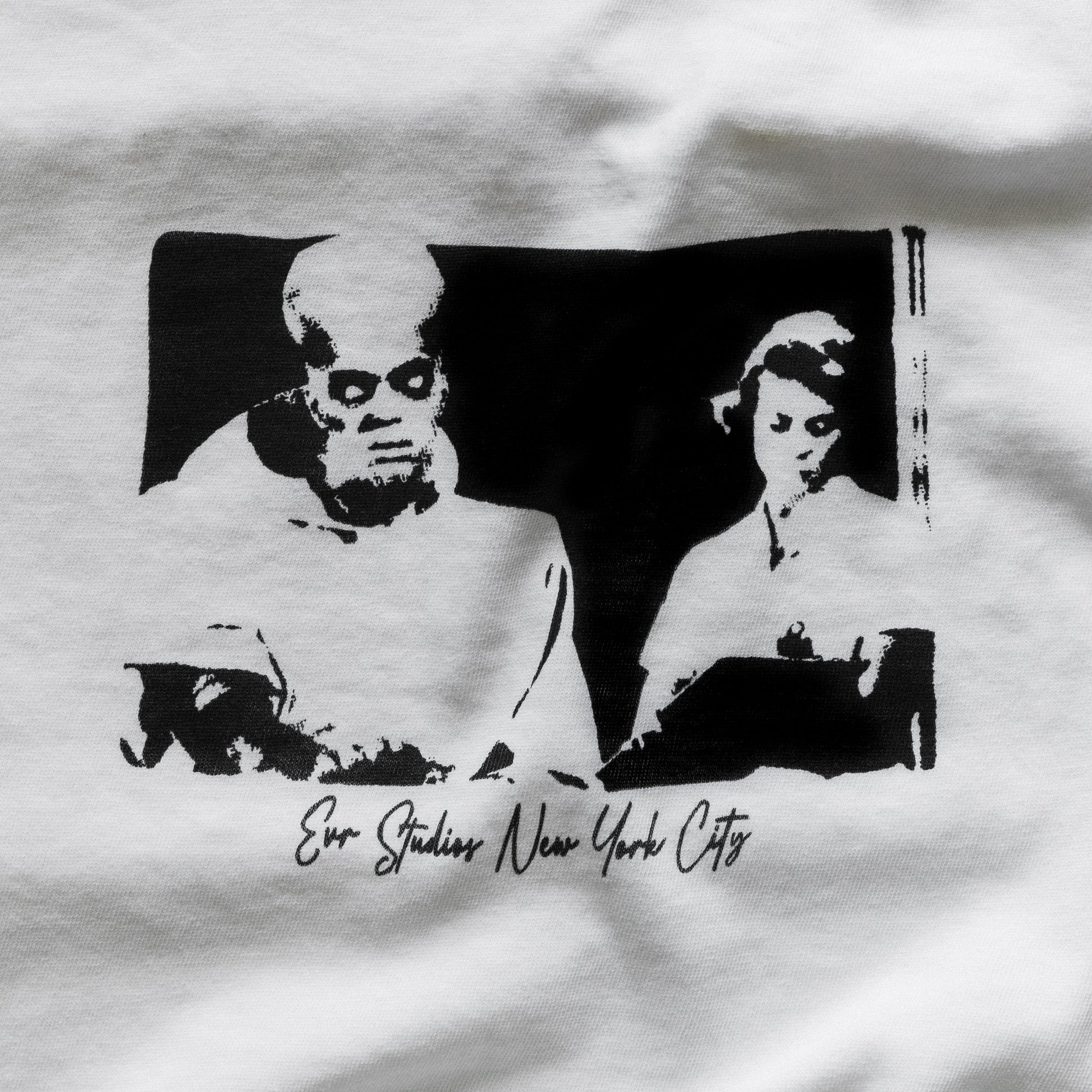 White t-shirt with black graphic design of a man and woman, featuring 'Evo Studios New York City' text.