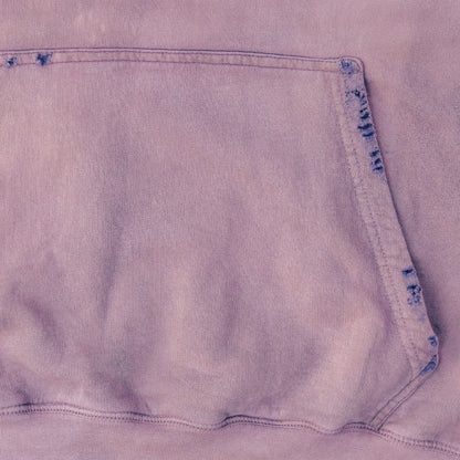 Close-up of a light purple hoodie fabric with a pocket detail