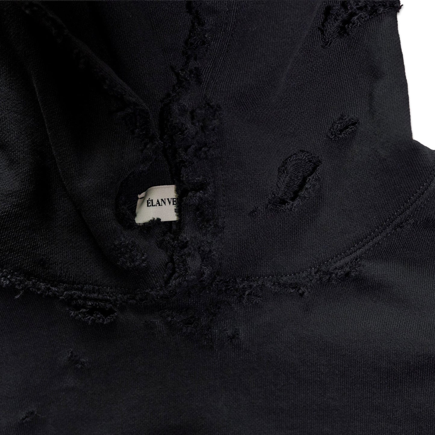 Close-up of a black jacket with a brand label on a white background