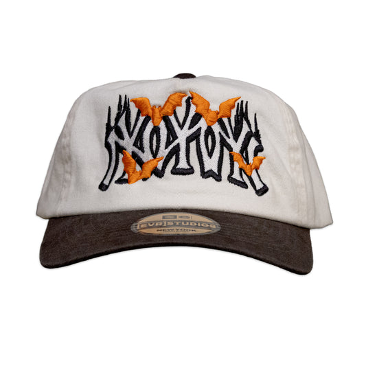 White cap with black and orange design on a white background