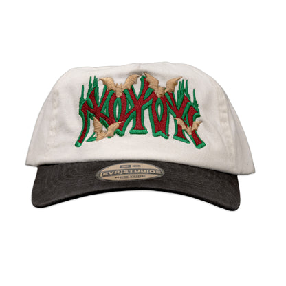 White cap with green and red text and beige accents on a white background
