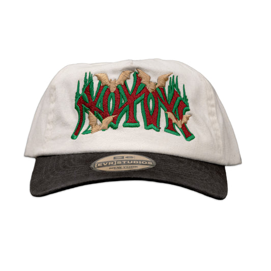 White cap with green and red text and beige accents on a white background